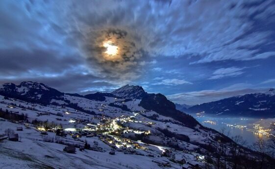 webcam panoramique avisec : village de montagne enneigé la nuit, lune brillante – Image webcam